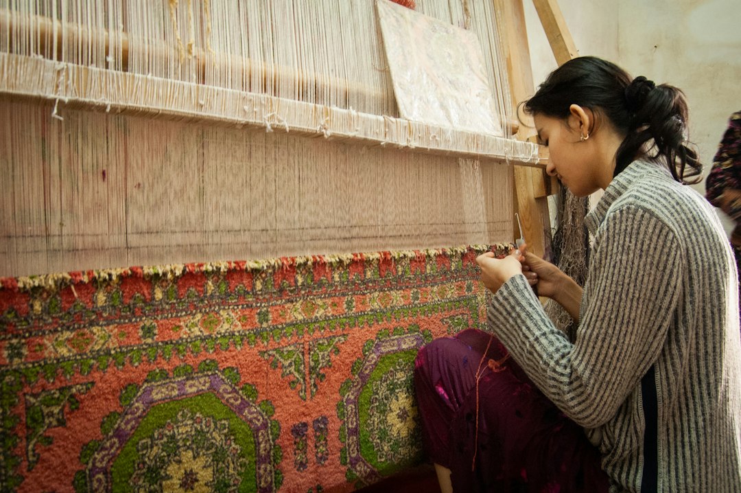 Master artisan weaving rug on traditional loom
