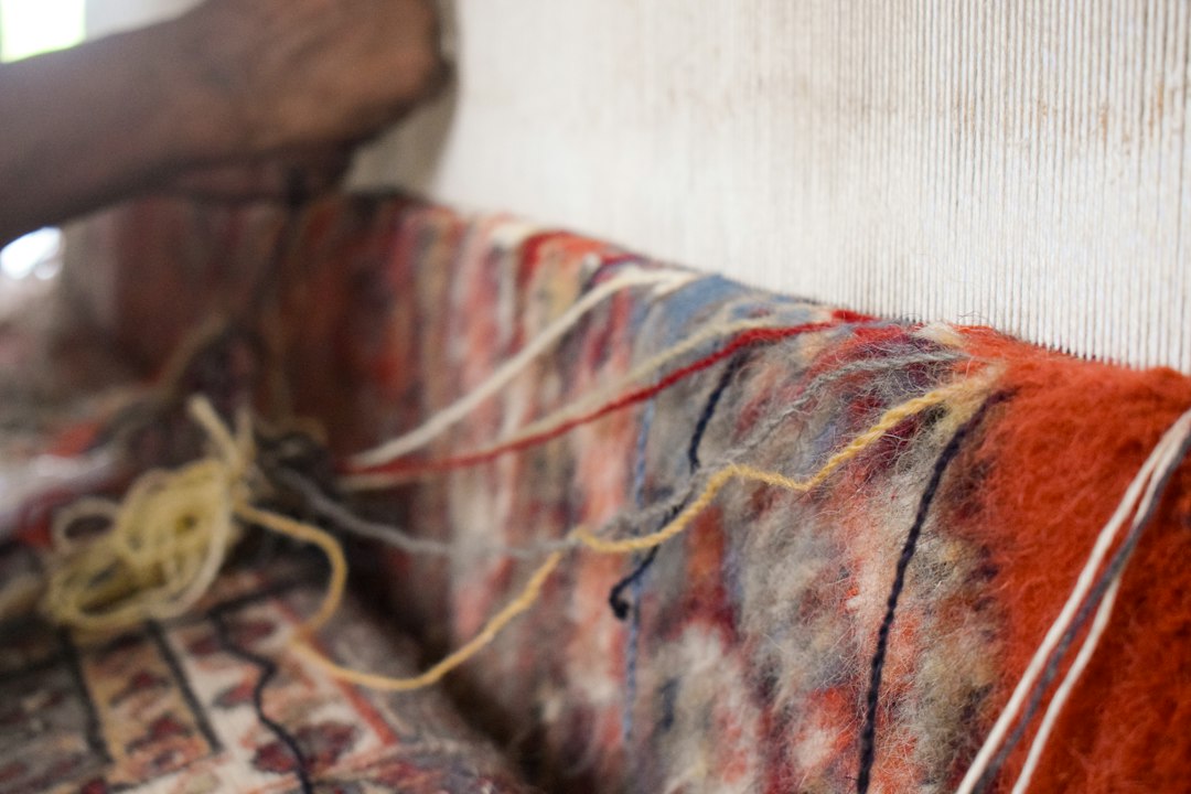 Master weavers handcrafting colorful custom rug